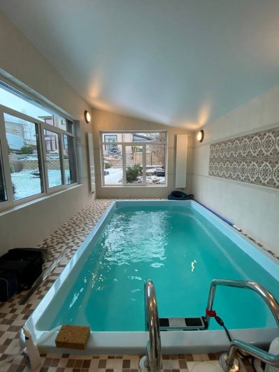 Композитный бассейн в светлом помещении с большими окнами и зимним пейзажем